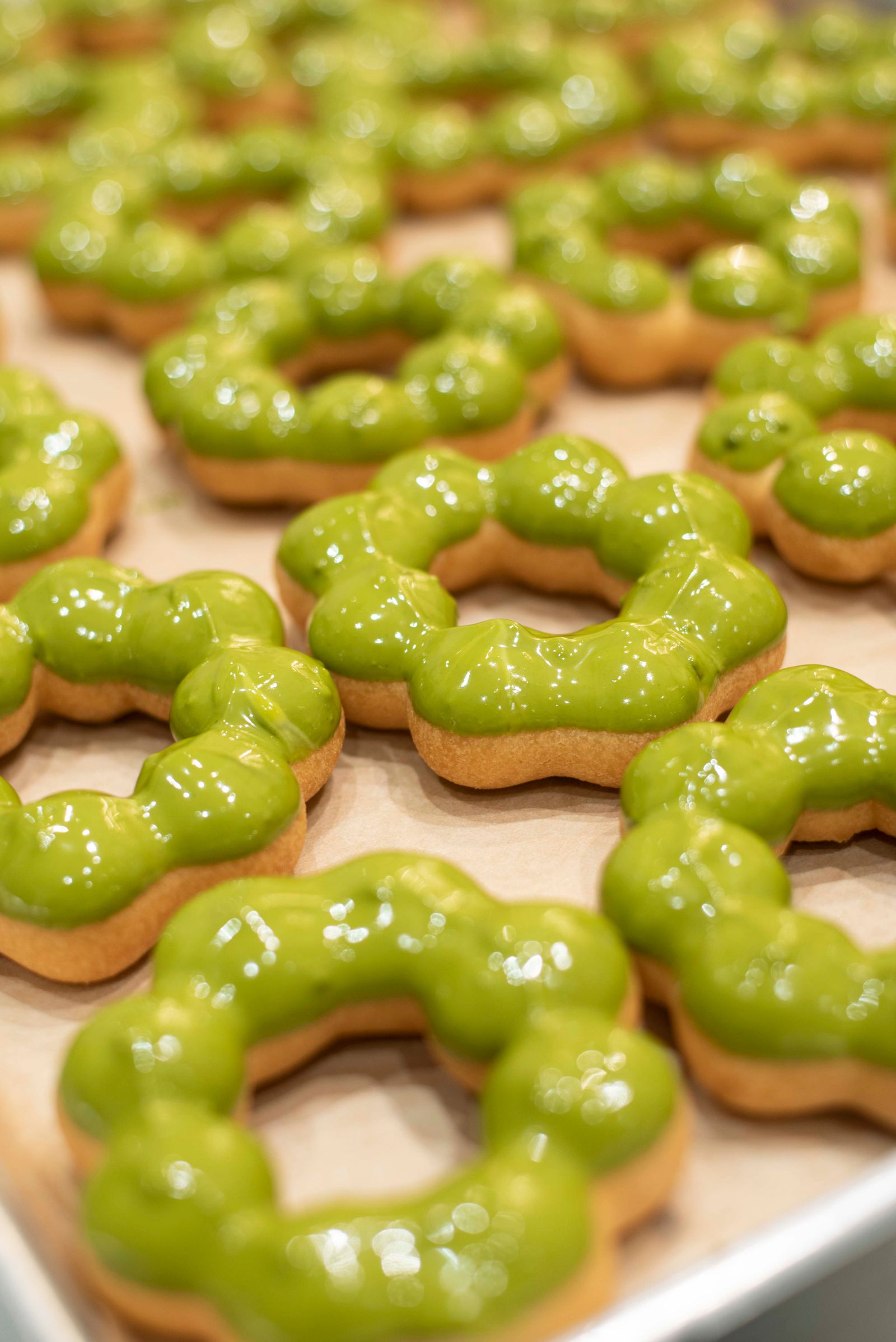 Fresh matcha-glazed mochi donuts in the classic pon-de-ring shape